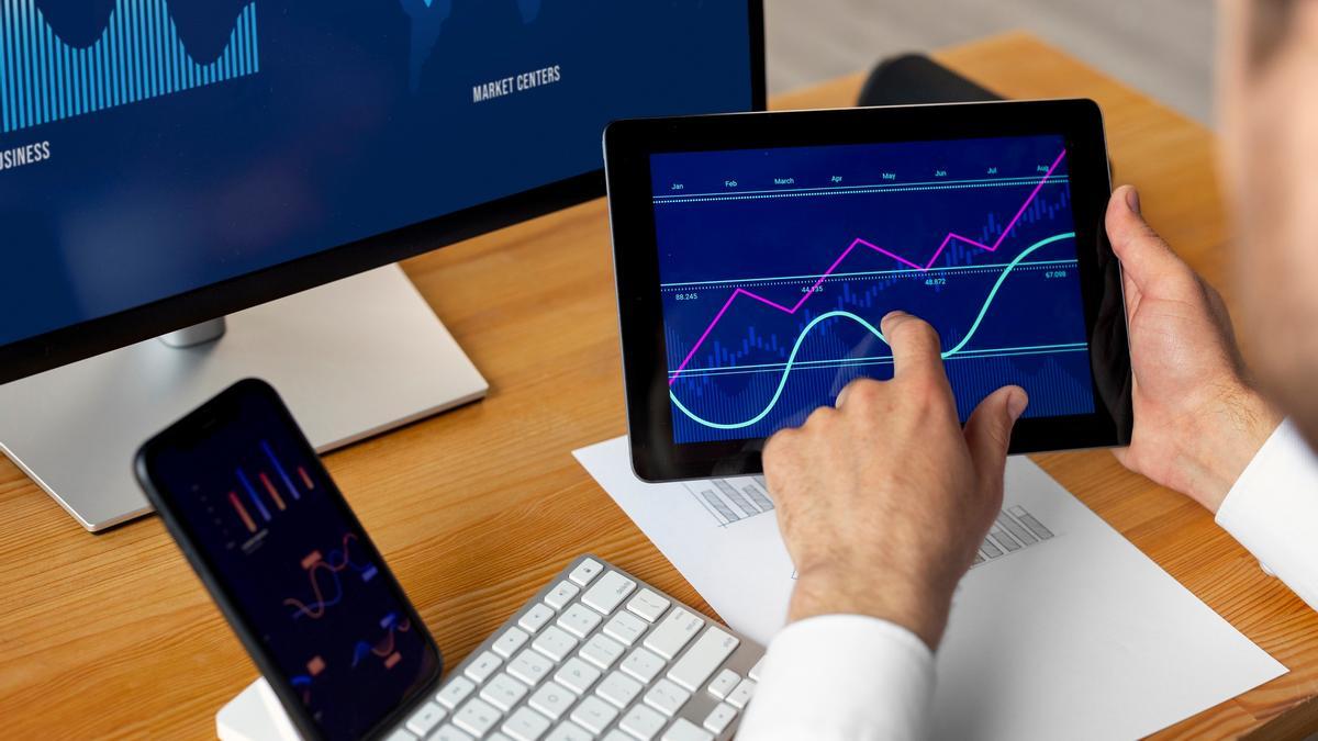 Un inversor  analiza unas gráficas en su tablet.