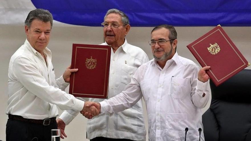 El presidente colombiano, Juan Manuel Santos, y el líder guerrillero, Rodrigo Londoño `Timochenko´, con el texto del acuerdo.