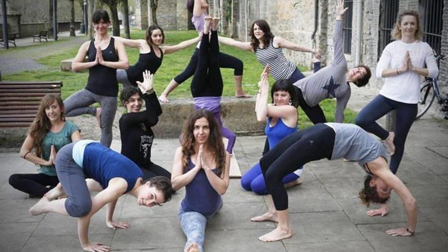 Marta Baena, en el centro haciendo el ‘spagat’, muestra diferentes posturas de yoga junto a algunas de sus alumnas, en el exterior de la escuela en la que imparte clases.