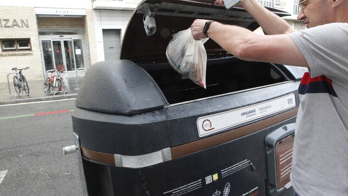 Un ciudadano deposita residuos en el contenedor de la fracción orgánica