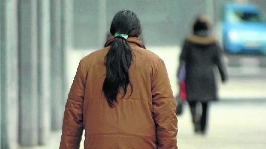 Una mujer en riesgo de exclusión camina con un carrito por la calle en Donostia.