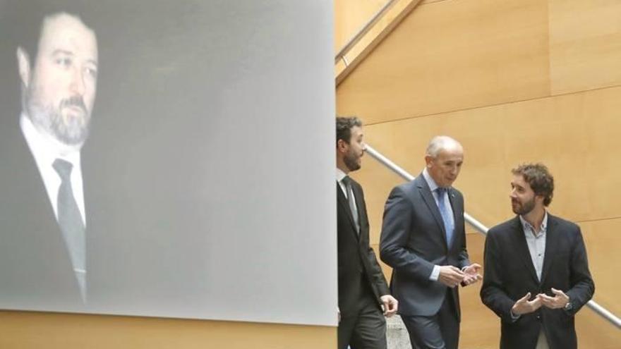 El consejero de Justicia del Gobierno Vasco Josu Erkoreka, (c) junto a los hijos de Lidón, ante una imgen de su padre