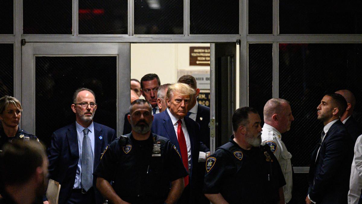 Donald Trump entra a la Corte Penal custodiado por policías.