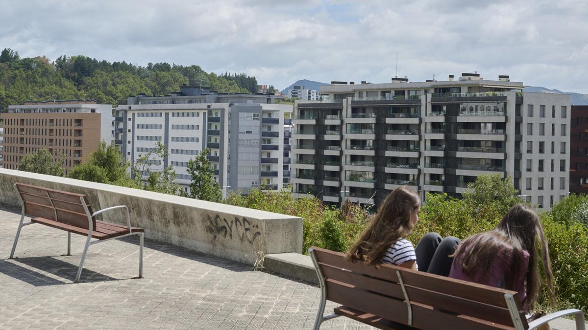 Dos jóvenes, delante de varios bloques de edificios del barrio de Lezkairu.