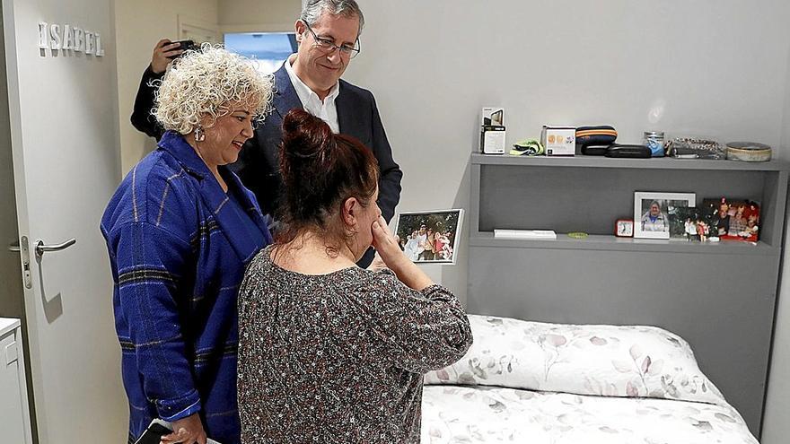 Isabel muestra a sus invitados, el diputado general, Markel Olano, y la diputada Maite Peña, una foto en su nueva habitación.  | FOTO: EFE