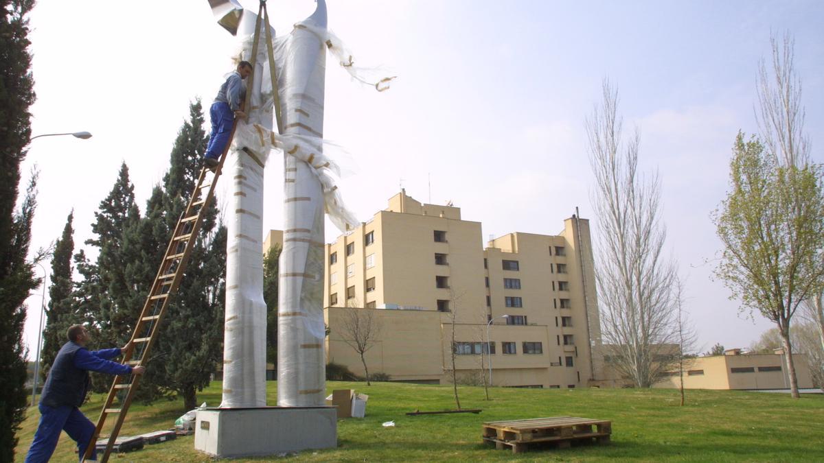 Dos operarios colocan la escultura &quot;Conciliación&quot; de Manuel Clemente Ochoa en el jardín del Hospital Reina Sofía de Tudela en 2006
