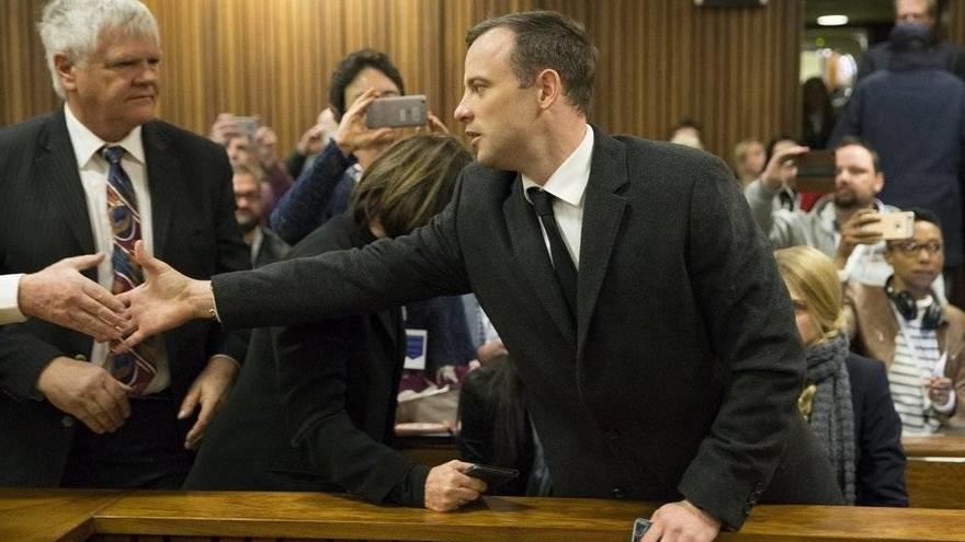 El atleta sudafricano Oscar Pistorius saluda a un conocido a su llegada a la sala del Tribunal Superior de Pretoria.