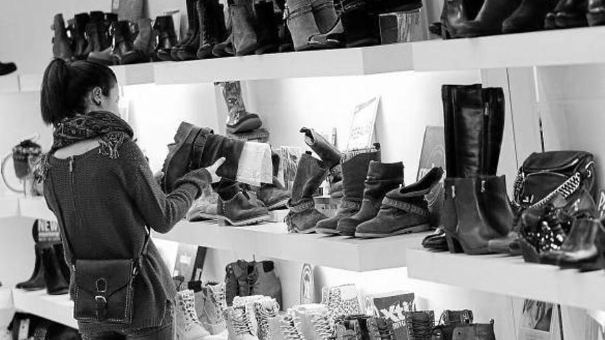 Una joven observa los precios de los zapatos en una de las tiendas del centro comercial Itaroa.