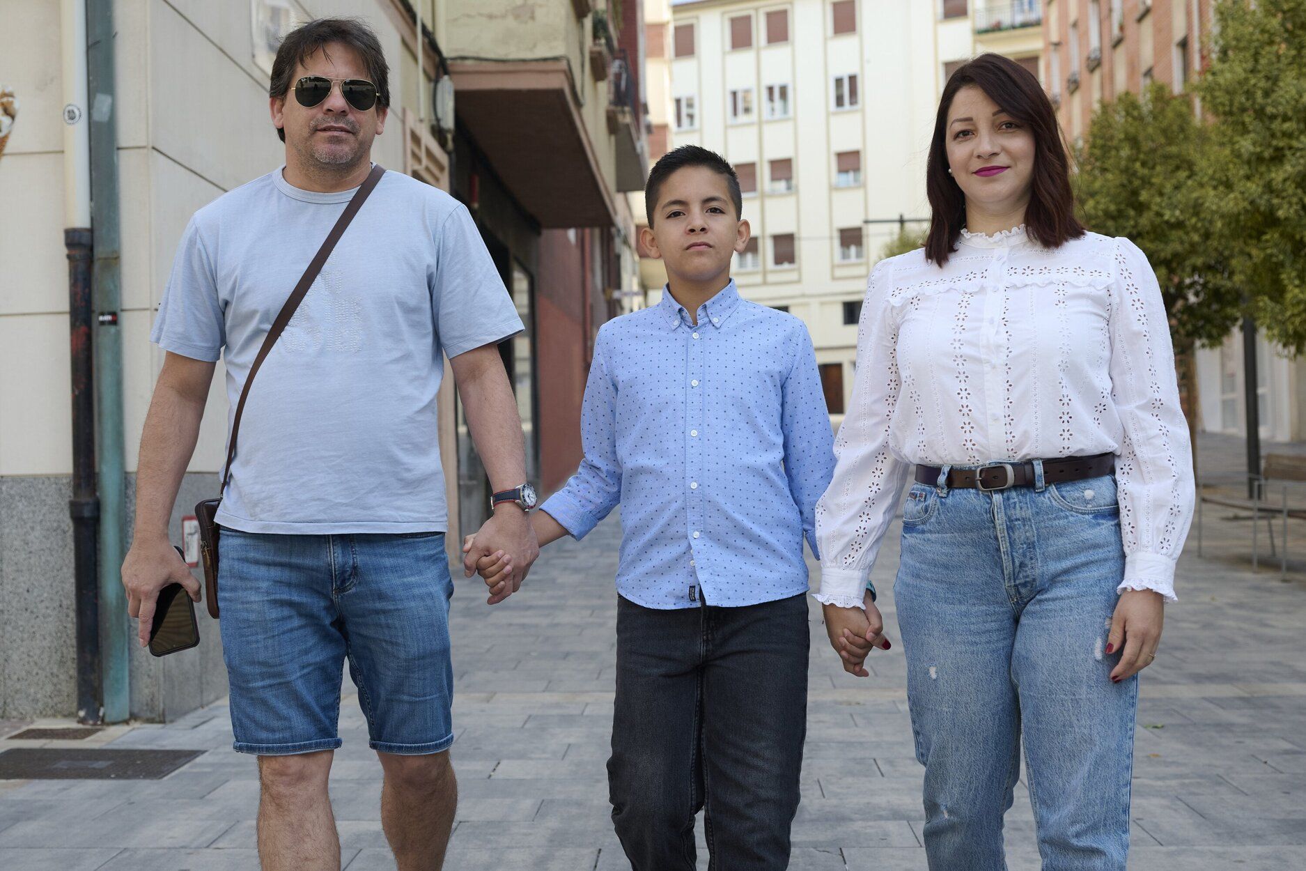 Los padres caminan con su hijo cogidos de la mano.