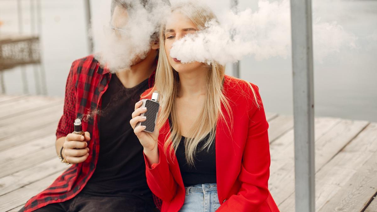 Una pareja fumando vaper