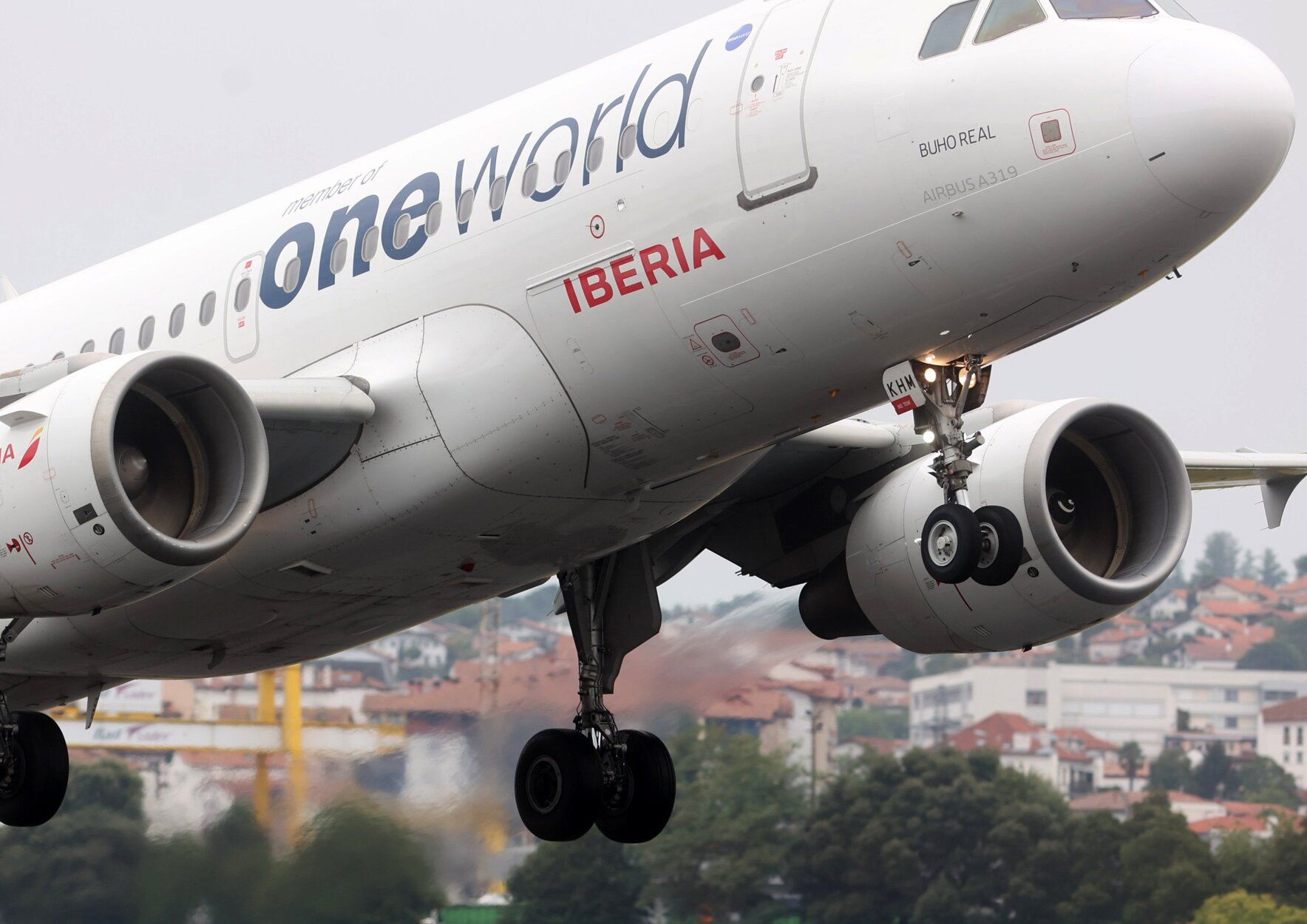 Un avión Airbus 319 de Iberia aterriza en el aeropuerto de Hondarribia, con Hendaia al fondo