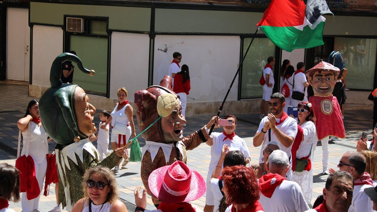 Un cabezudo ondea una bandera palestina en la calle Herrerías.