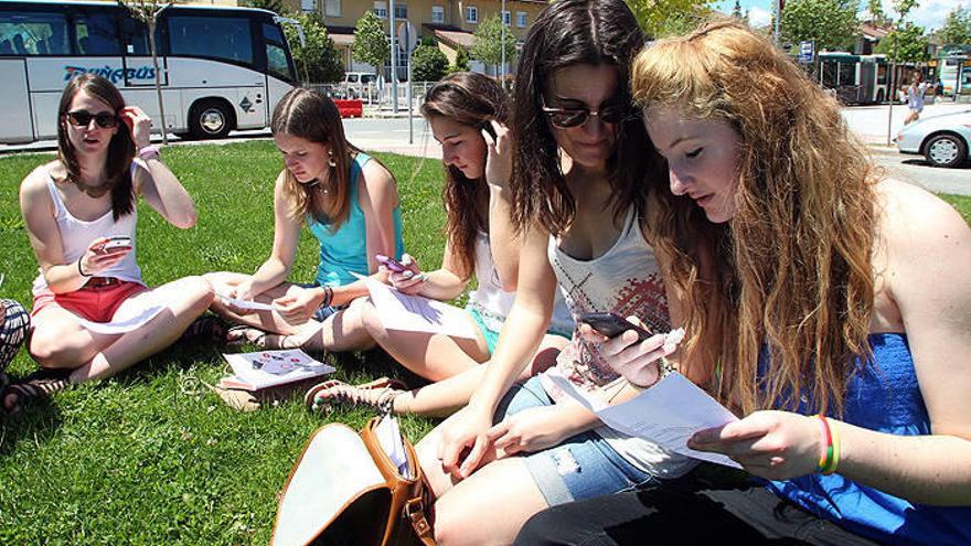 Alumnas del IES Zizur comprueban ayer a mediodía las notas de Selectividad en el móvil y en papel en el parque Talluntxe.