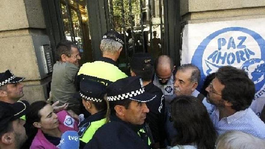 Desahucio de la sede de la ONG Paz Ahora por el impago del alquiler durante diez meses, a pesar de las protestas de media docena de miembros del 15-M, que han intentado impedir la entrada de la comisión judicial.