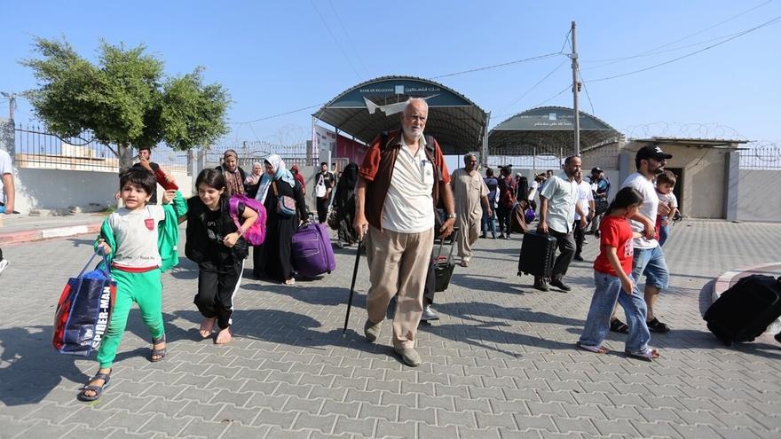 Refugiados palestinos cruzan el paso de Rafah para adentrarse en suelo egipcio.