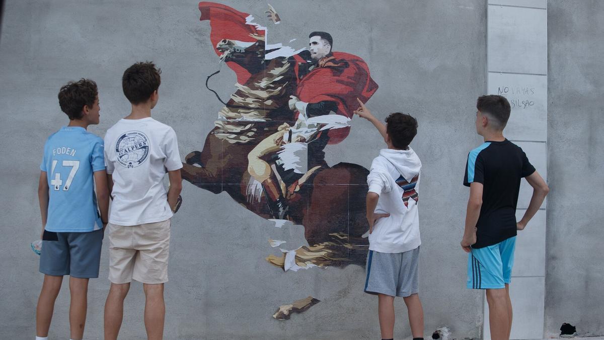 Varios jóvenes, mirando el mural.