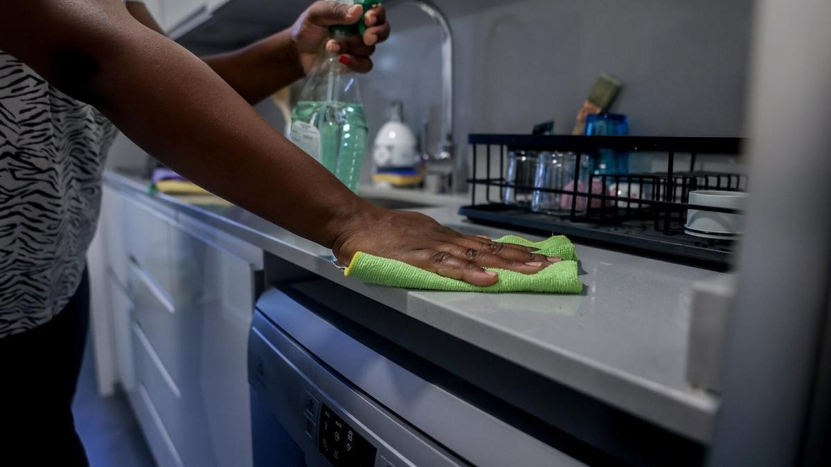 Una empleada de hogar friega en la cocina del domicilio donde trabaja como interna.