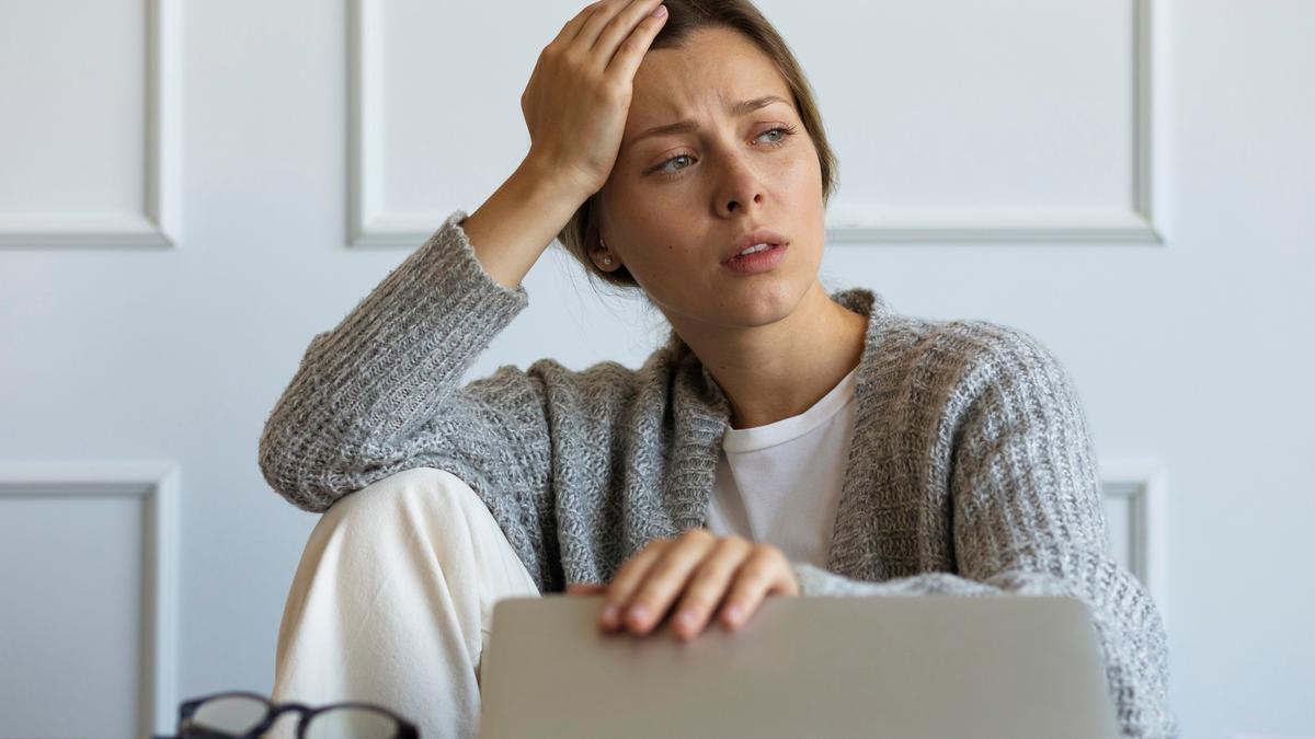 Una mujer estresada en su puesto de trabajo.
