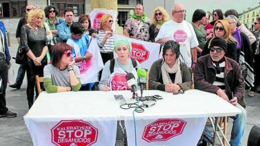 Miembros de Stop Desahucios Bidasoa junto a la afectada, en el centro, ayer en la plaza San Juan.