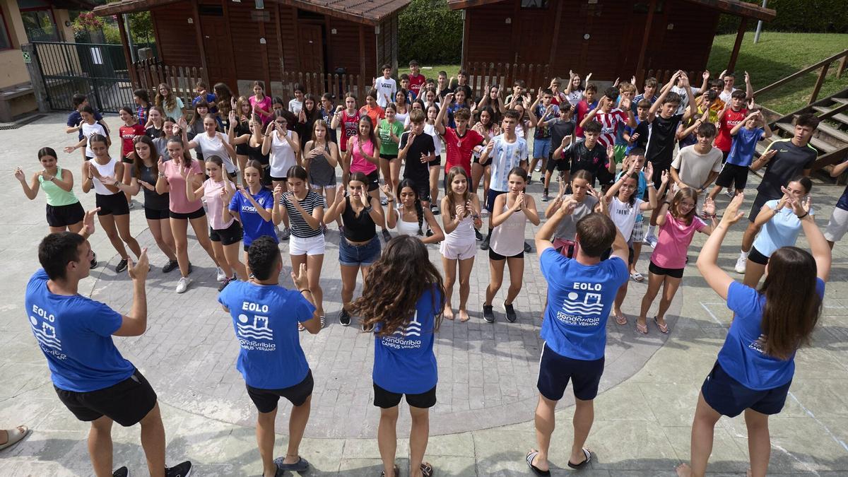 Un grupo de monitores anima a los menores durante una dinámica clase de zumba, que combina diversión y movimiento.