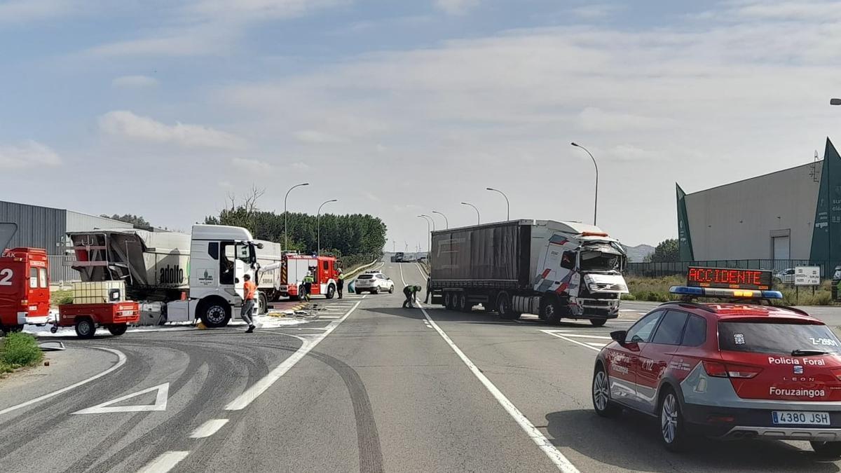 Policías forales y bomberos junto a los camiones accidentados.