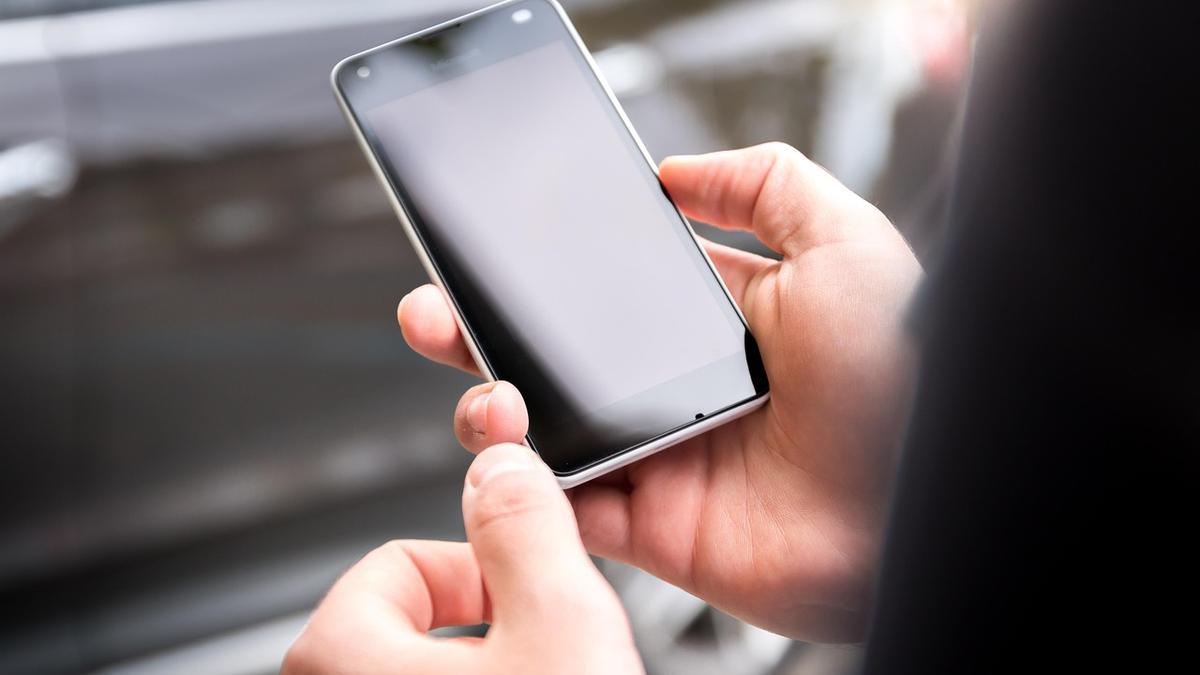 Una persona mira un teléfono móvil