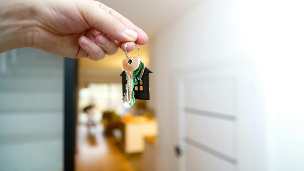 Agente inmobiliario con las llaves de una casa nueva.