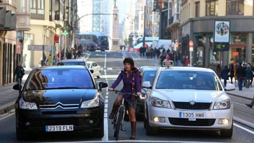 Karioka espera, rodeada de coches, en un semáforo de la calle Buenos Aires.