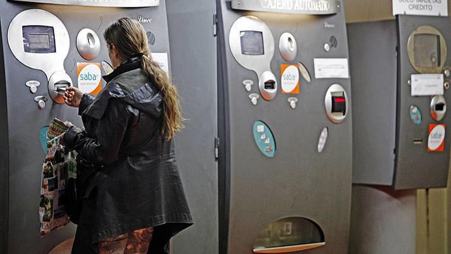 na mujer se dispone a pagar en un cajero automático del parking subterráneo de la plaza del Castillo.