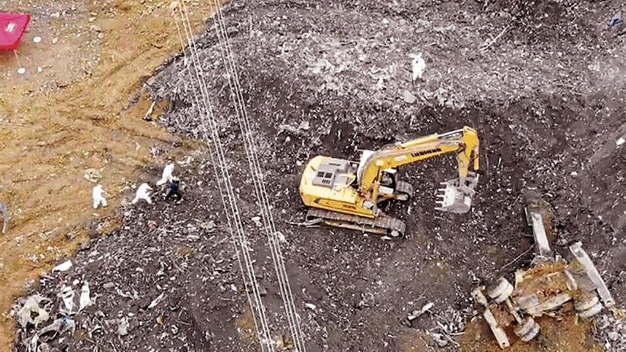 Los operarios localizaron ayer una excavadora, que se ve a la derecha, sepultada el pasado día 6.