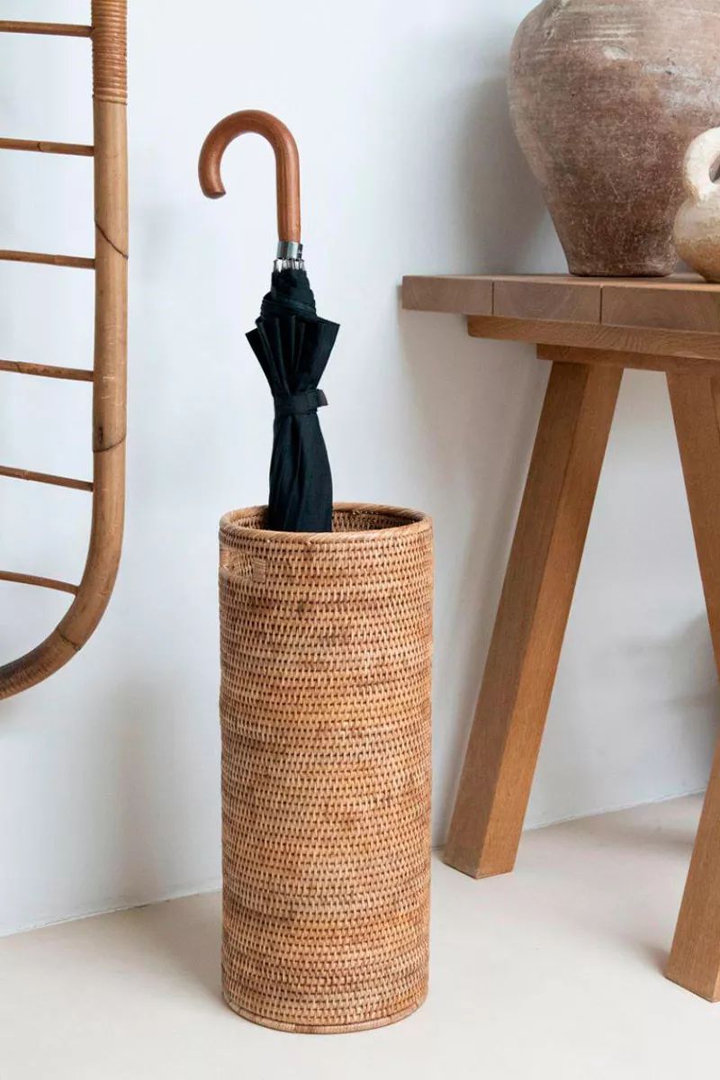 Paragüero redondo de mimbre que aporta calidez al espacio.