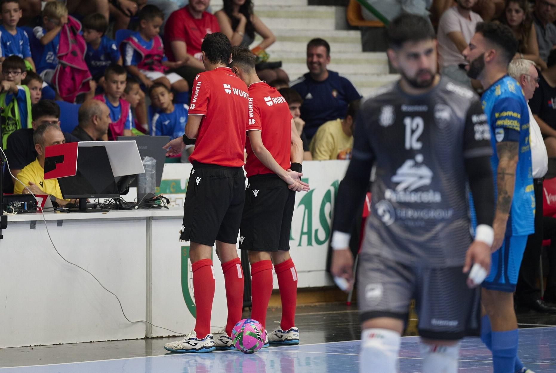 Los árbitros, consultando a través del soporte vídeo una acción.