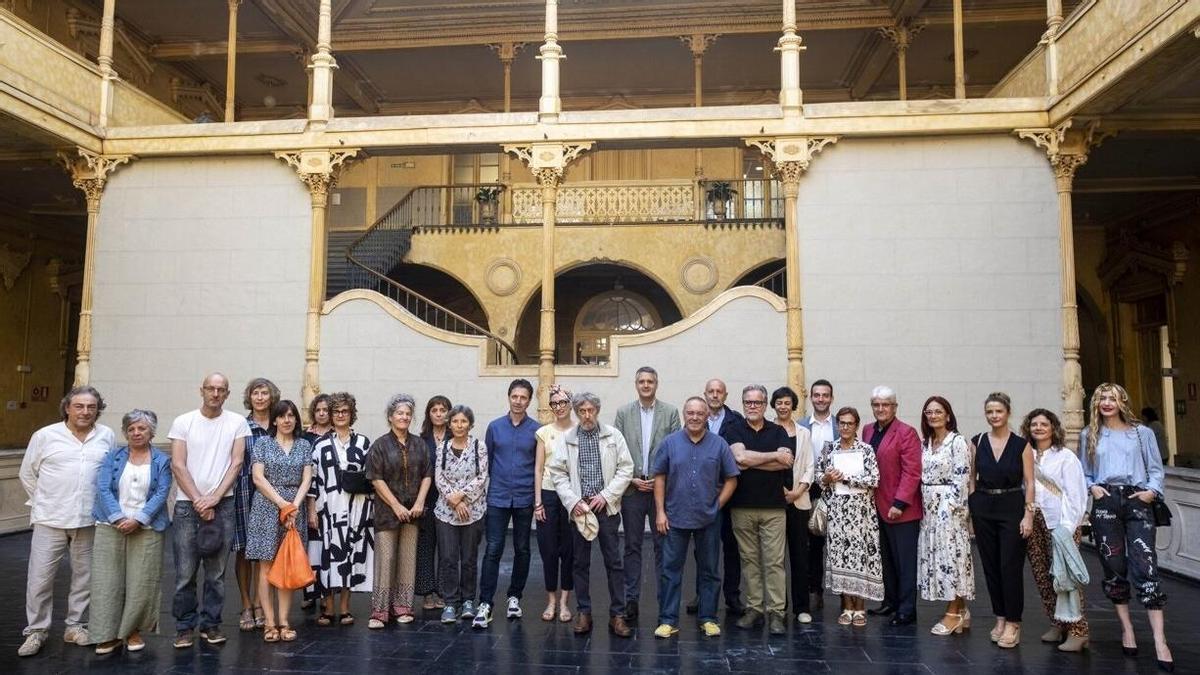 El director general de Cultura-Institución Príncipe de Viana, Ignacio Apezteguía, y el autor del libro, Toni Sasal, junto a varios artistas retratados en la obra.