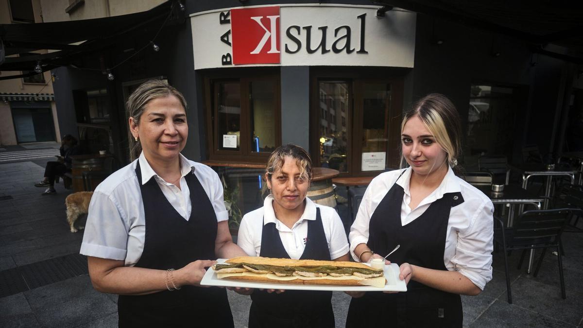 De izquierda a derecha, Yurimar Aranguren López, Ángela Guerrero Villegas y Andrea Colmenero Isla, con uno de los bocatas XXL del bar Ksual.