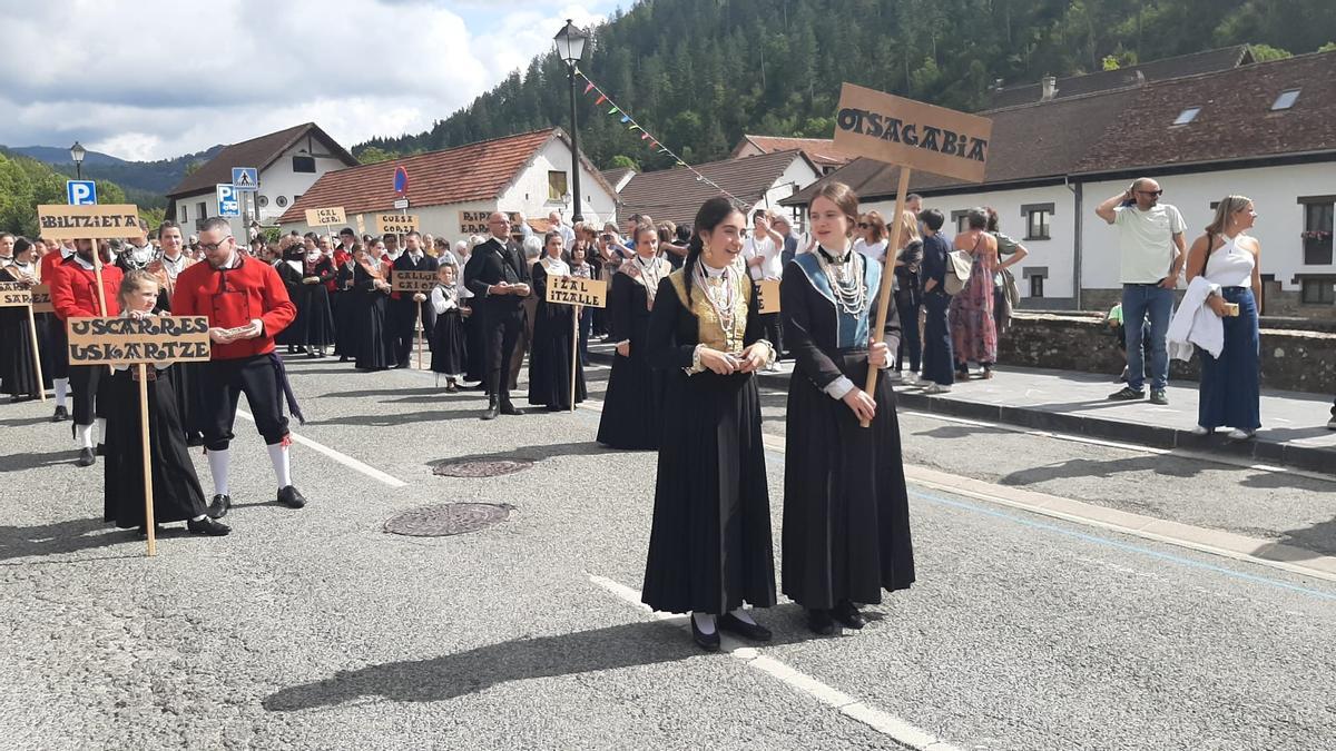 Parejas de los pueblos del valle caminan en el desfile hacia la plaza.