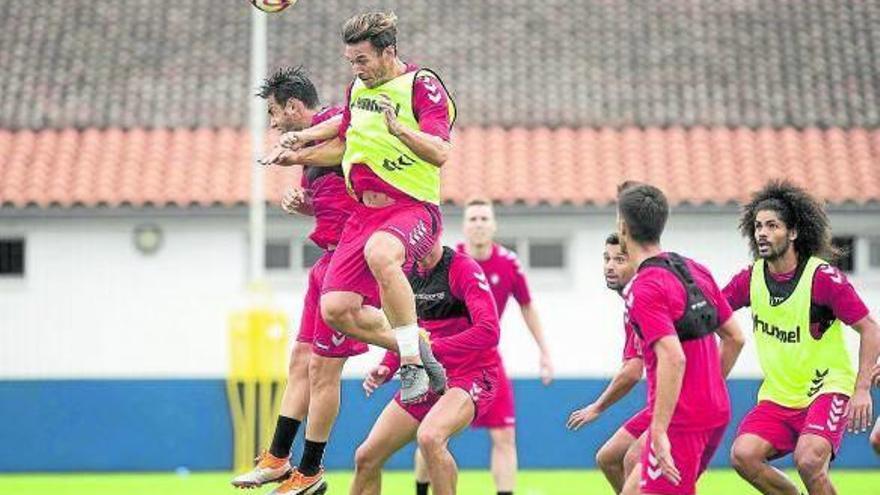 David Rodríguez y Xisco saltan a por un balón en presencia de varios de sus compañeros.