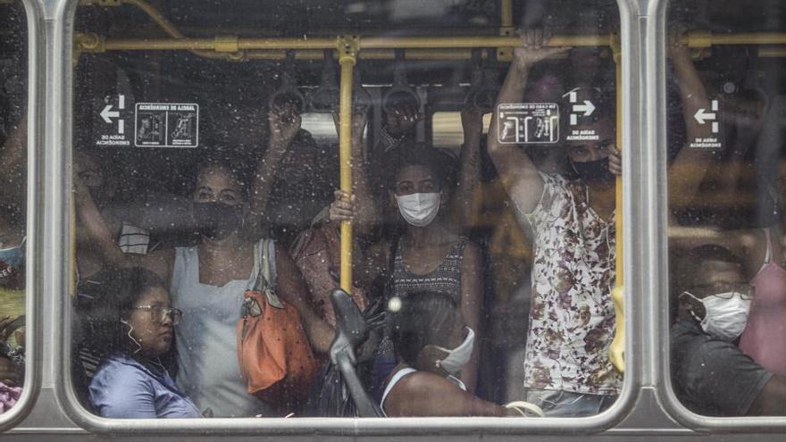 Gente con y sin mascarilla amontonada en un autobús de Río a pesar de las elevadas cifras de muertes por coronavirus.