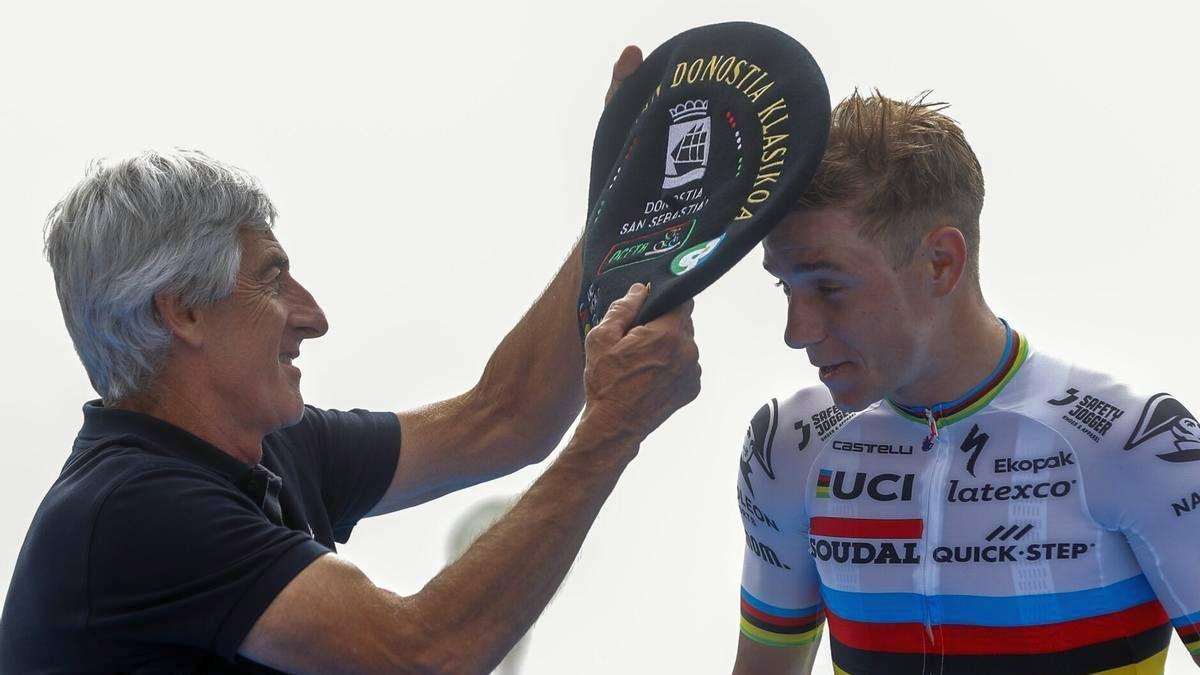 Remco Evenepoel recibe una txapela de manos del exciclista Marino Lejarreta tras ganar la Clásica de San Sebastián en 2023.