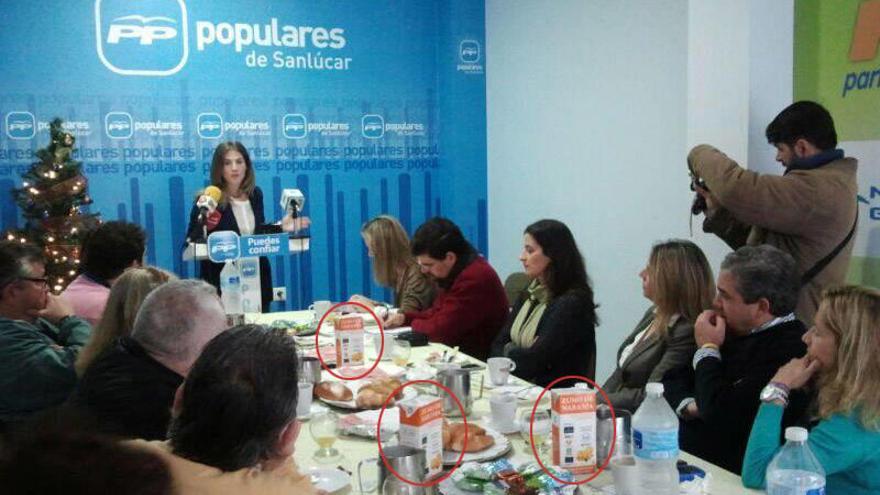El PP sirve zumos del Banco de Alimentos en un desayuno navideño con la prensa.
