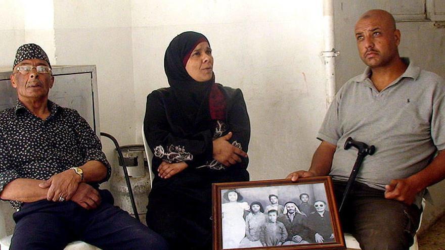 Refugiados palestinos muestran una fotografía en blanco y negro en la que se aprecia la familia del patriarca, Halil Munir Ahmad Yaber, quien hoy tiene 69 años, doce hijos y 54 nietos. Este refugiado palestino (izquierda) fue testigo de la matanza a manos
