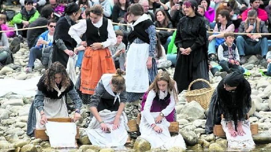 Al paso de las almadías las mujeres lavan la colada en el río.