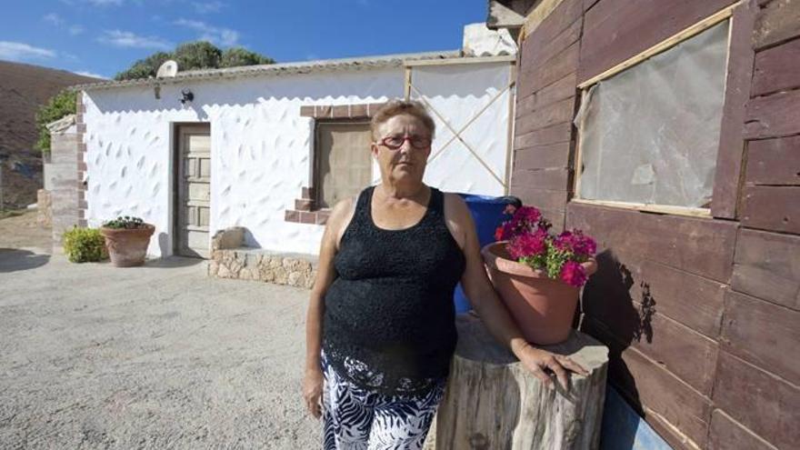 Josefa Hernández, ‘la abuela de Fuerteventura’, posa junto a la vivienda que comparte con su familia.