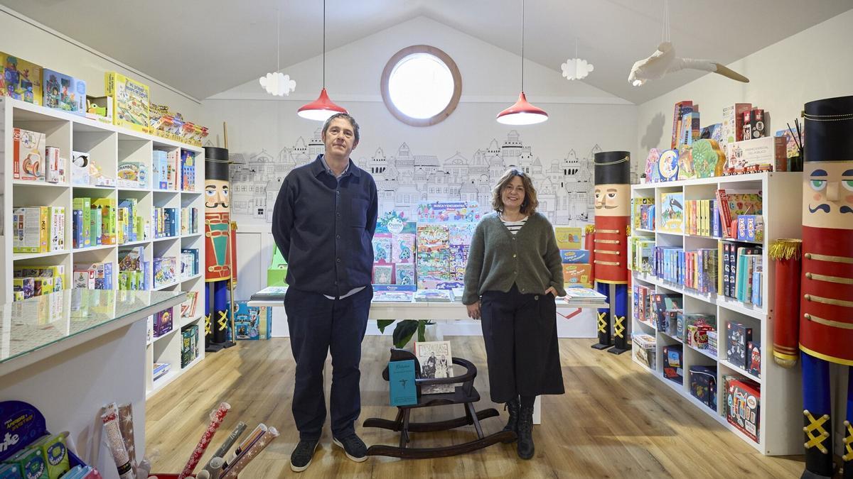 Mikel Olaiz, dueño de la librería La Valeta, en Erripagaña, e Idoia Iribertegi, la artista que ha pintado un mural en el escaparate.