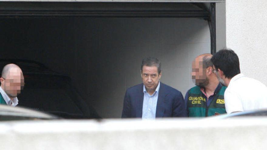 Eduardo Zaplana, acompañado por agentes de la Guardia Civil durante el registro de su chalé de Benidorm ayer tarde.