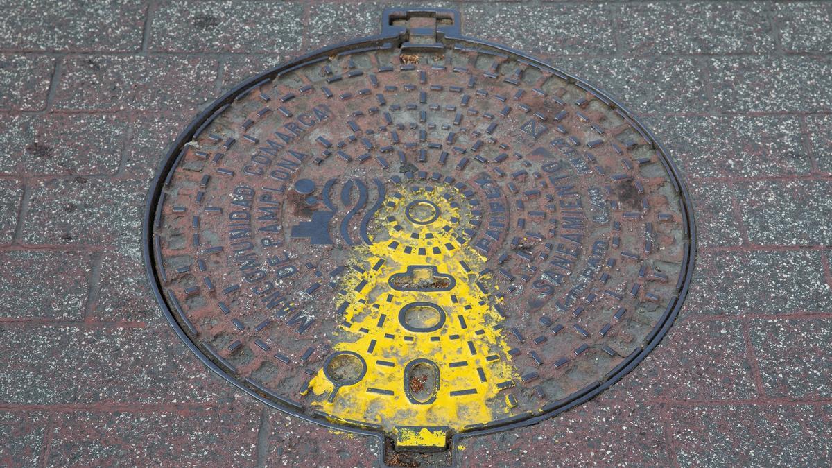 Alcantarilla de Pamplona con la marca amarilla que indica que ha sido desinfectada y desratizada.