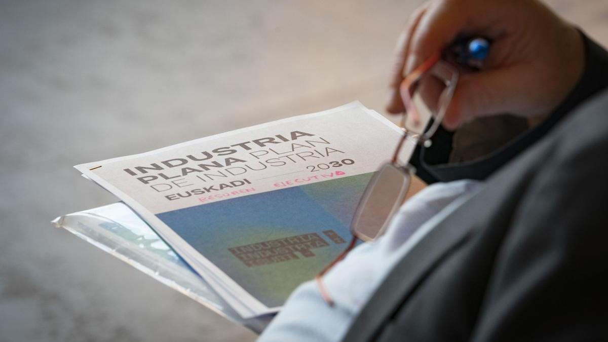 Una persona con un informe sobre el Plan de Industria de Euskadi