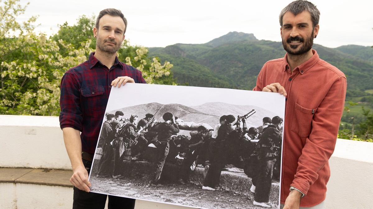 Aitor Azurki y Aitzol Arroyo posan en San Marcial, en Irun, con una imagen del mismo lugar con combatientes de la Guerra Civil. / Iker Azurmendi