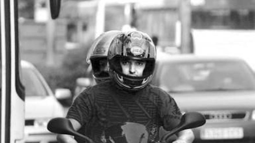 Dos jóvenes circulan en ciclomotor por Pamplona.