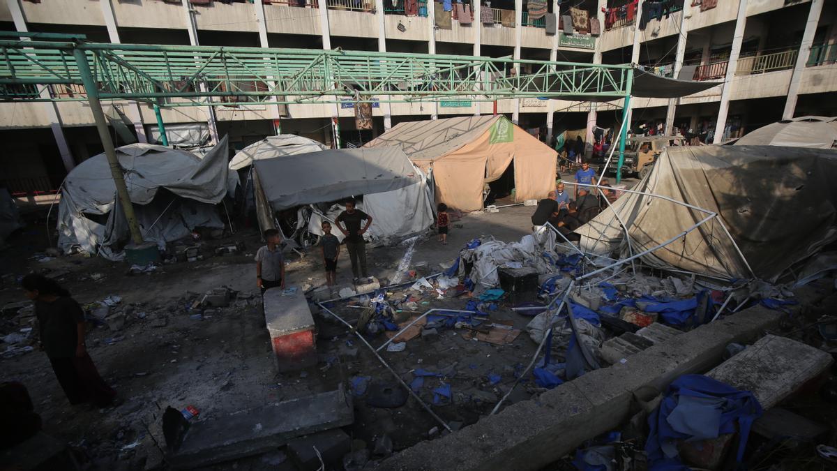 Palestinos evalúan los daños después de que un ataque israelí impactara por la noche en la escuela Al-Majda Wasila, que albergaba a desplazados.