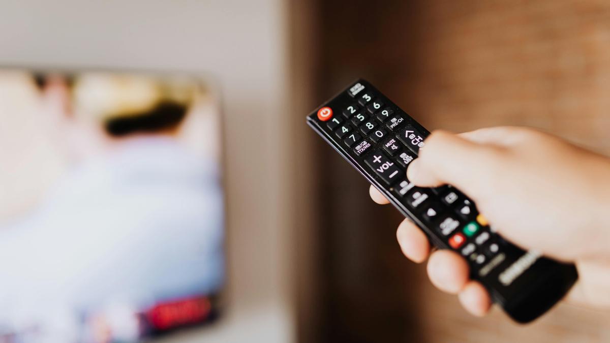 Una persona utilizando un control remoto de televisión.
